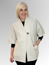 Crafted from Woolmark certified wool, the Boiled Wool Cape in cream combines timeless elegance with contemporary design. The relaxed oversized fit is intentionally loose, perfect for layering and creating effortless, modern silhouettes. Functional pockets add practicality to the stylish single-button closure. Versatile and sophisticated, it's designed to elevate any wardrobe with understated luxury.