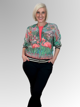 Bring playful style to your wardrobe with Orientique’s Flamingo Digital Print Zip Jacket. Crafted from lightweight rayon with a luxurious satin finish, it offers effortless comfort in a relaxed bomber silhouette. The striking digital print is perfectly elevated by eye-catching black and gold lurex bands at the cuffs and hem. Complete with a breezy zip front, it is the perfect fashion-forward layer to easily elevate any everyday outfit.