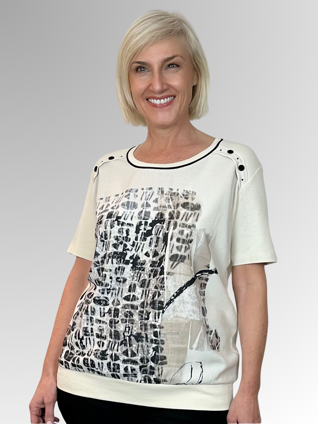 Made in Portugal, the Helena Top by Bagoraz combines playful style with comfort. Crafted from a blend of cotton and polyester, it features a contrast trim neckline and charming button and stud details on the shoulders. The front made from polyester showcases an abstract design, while the back is soft, plain cotton. Finished with a waistband and a generous relaxed fit, this top brings a fun, breezy vibe to your day.