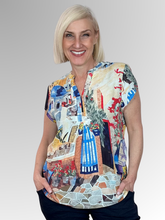Transport your wardrobe to the sun-drenched Mediterranean with the Santorini Cap Sleeve Top by Equinox Clothing. Featuring a vibrant, picturesque print inspired by the iconic blue domes, stone paths, and blooming bougainvillea of Greece, this top brings an instant resort-wear feel to your everyday style.