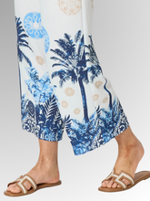 Embrace effortless summer style with the Azure Escape Print Pant, a striking statement piece designed for relaxed, warm-weather dressing. Showcasing a beautiful, resort-inspired print featuring classic palm motifs and ornate blue patterns against a crisp white background, these wide-leg pants inject modern colour and fluid movement into your everyday wardrobe. Crafted from a premium blend of Viscose and Nylon, the subtly textured fabric provides an airy, lightweight feel that is perfect for balmy climates.