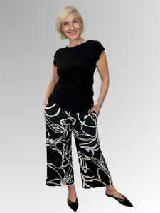Bring a fresh and playful vibe to your wardrobe with the Lotus 7/8 Pant by Philosophy. Showcasing a chic black, beige and white print, these wide-leg pants offer a modern silhouette that’s effortlessly stylish. The elastic waist ensures comfort, while handy pockets add practicality. Perfectly cropped at 7/8 length, they’re made from easy-care polyester elastane for a smooth fit and simple maintenance.