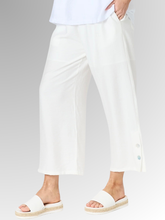 Meet your new wardrobe foundation. The Essential Button Pant in ivory is meticulously crafted for the modern woman who refuses to sacrifice comfort for style. Whether you are running weekend errands or dressing up for a casual evening out, these pants deliver a beautifully polished look. Designed with a relaxed, wide-leg silhouette and a chic cropped length, this piece offers a breezy, fashion-forward cut that moves beautifully with you.