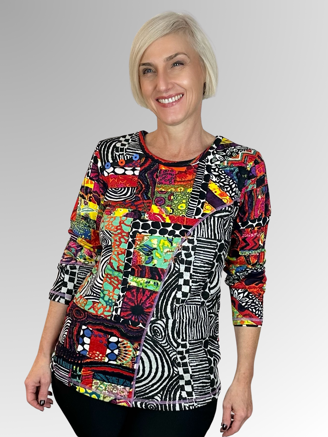 Add some fun to your wardrobe with Orientique's Runaway Train Patch Top! This playful top features a splash of colour together with a spliced design that combines different textures and fabrics. The highlight trim details of buttons and stitching add a quirky touch to this rayon and spandex top.