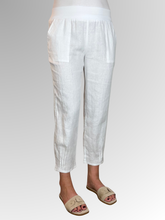Elevate your warm-weather wardrobe with the Ankle Tuck Linen Resort Pant in White, the ultimate choice for effortless summer style. Perfectly balancing a trendy silhouette with everyday practicality, these pants are crafted from premium, breathable linen designed to keep you cool and comfortable all day long.