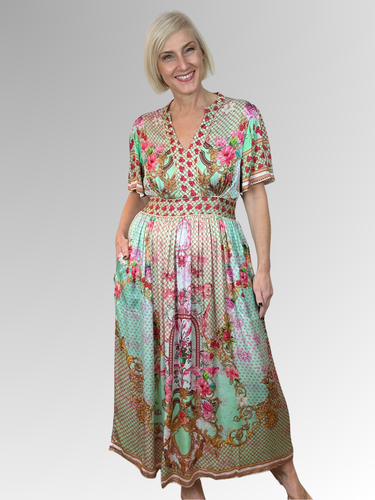 Step out in style this summer with the Lula Soul Pellicano Midi Dress in Mint. Featuring an elegant scarf print and delicate gold embroidery trim, this chic dress is crafted from silky viscose for a luxurious feel. The shirred waistband at the back ensures a flattering fit, while handy pockets add practical charm. Perfect for any occasion, it’s the playful yet sophisticated piece your wardrobe needs.