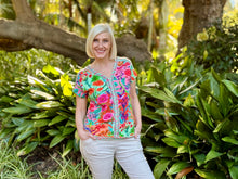 Capture a sense of natural beauty with the Songbird V-Neck Top by Escape. Woven from a premium blend of cotton, rayon, and spandex, this lightweight tee delivers an easy, unrestricted drape with plenty of comfortable give. It features an exquisite botanical print showcasing vibrant songbirds and hummingbirds nestled amidst lush tropical flowers, rich greenery, and warm orange-pink skies.