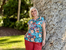 Bringing a touch of global inspiration to your everyday wardrobe, the Gordes Roll Neck Top by Orientique is an artful and effortlessly relaxed piece beautifully crafted from 100% organic cotton to ensure premium breathability and all-day comfort. This striking top features a vibrant teal base adorned with a rich print of intricate Eastern botanical and architectural motifs, perfectly balanced by a soft rolled neckline that adds a subtle, elegant detail to the upper silhouette.