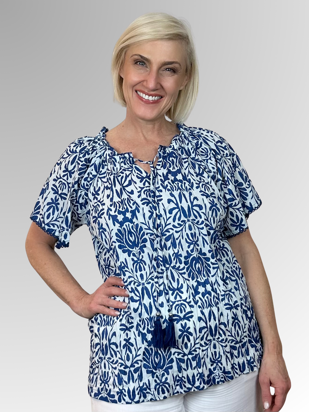 Beat the heat in style with the gorgeous Buzios Tassel Top from Orientique! Made from soft organic cotton, this charming piece features a soft ruffled neckline, tasseled strings and short sleeves that frame the shoulders perfectly. It's the ultimate combo of comfort and fashion that'll keep you looking fabulous and feeling cool all summer long.