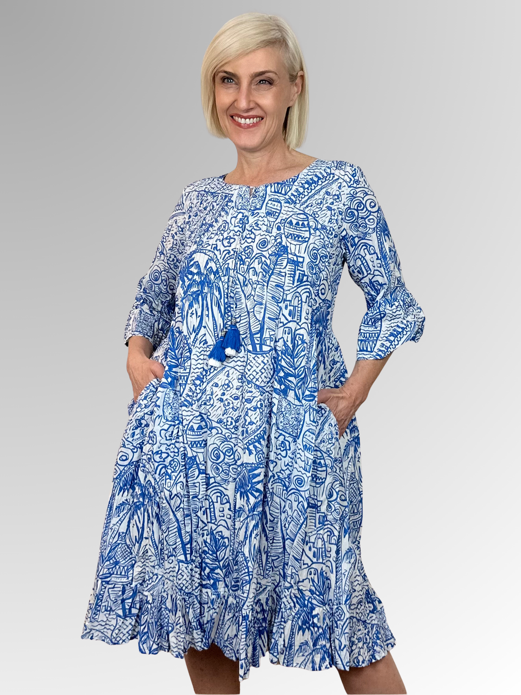 Embrace the sunshine in the Aksharay Blue 3/4 Sleeve Frill Dress by Orientique. Made from organic crinkle cotton, this dress brings instant personality with its delightful frills adorning the sleeves and hem, paired with playful tasseled accents. The 3/4 sleeves deliver that perfect harmony of ease and sophistication, creating a look that's both refreshingly cool and effortlessly chic.