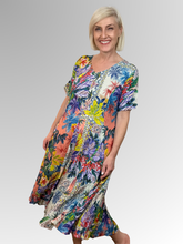 Introducing the Aruba Godet Dress by Orientique! Made from soft, sustainable rayon, this dress features a hand painted tropical print in a gorgeous array of colours. The crinkle fabric is oh-so-comfy with no ironing required. Featuring short sleeves, a flattering V-neckline and godet panels through the skirt that create a beautiful drape and swing; Perfect for summer, this cool and flowy dress is a must-have addition to your wardrobe.